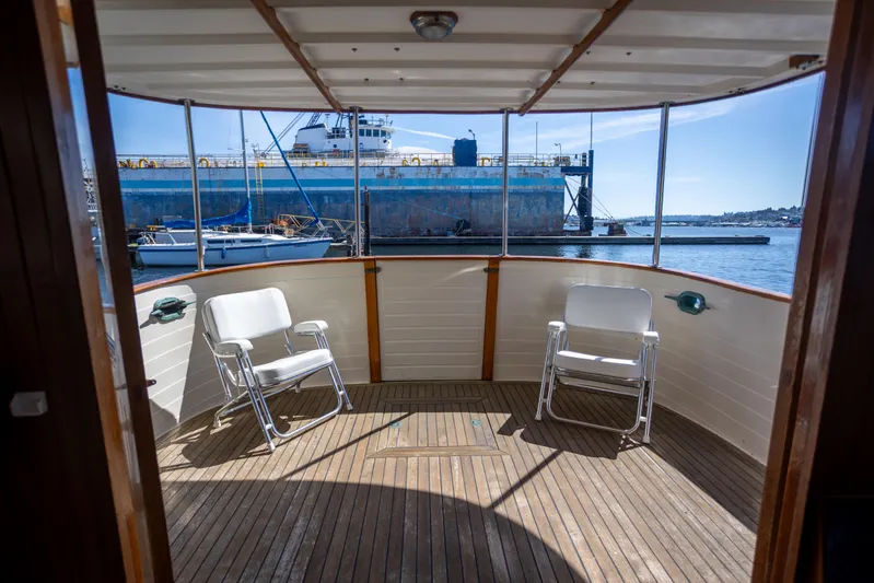 Amazing Grace Yacht Photos Pics 1983 Kadey-Krogen Manatee 36 yacht deck with chairs, overlooking marina and industrial ship.