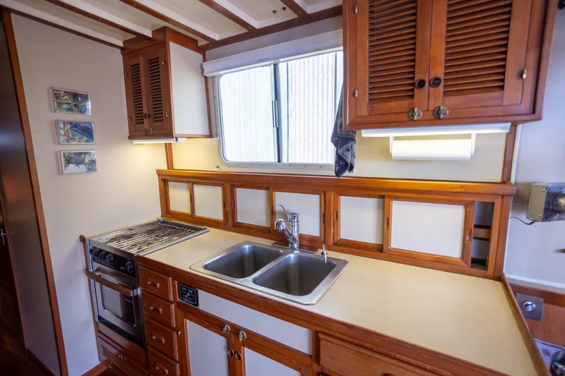 Amazing Grace Yacht Photos Pics 1983 Kadey-Krogen Manatee 36 kitchen with wooden cabinets, dual sink, and stove.
