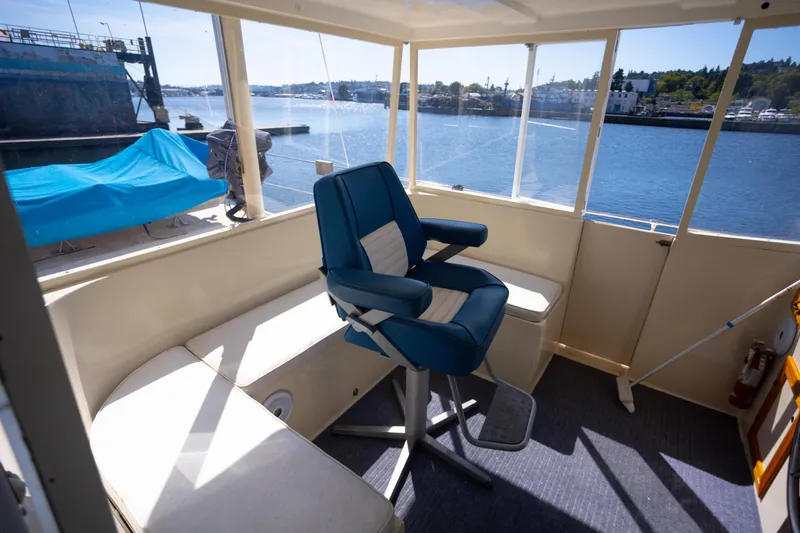 Amazing Grace Yacht Photos Pics Interior of 1983 Kadey-Krogen Manatee 36 boat with blue captain's chair and waterfront view.