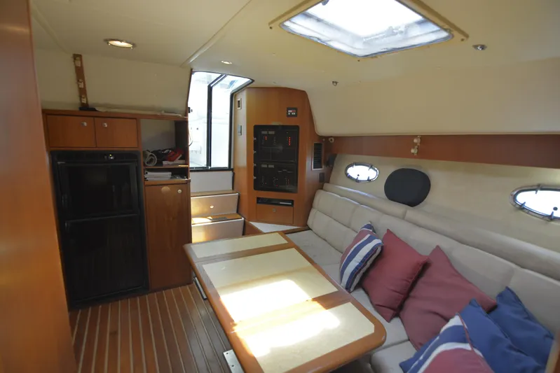 Uncouth Yacht Photos Pics Interior of 2000 Tiara Yachts 4100 Open with seating, table, and kitchenette.