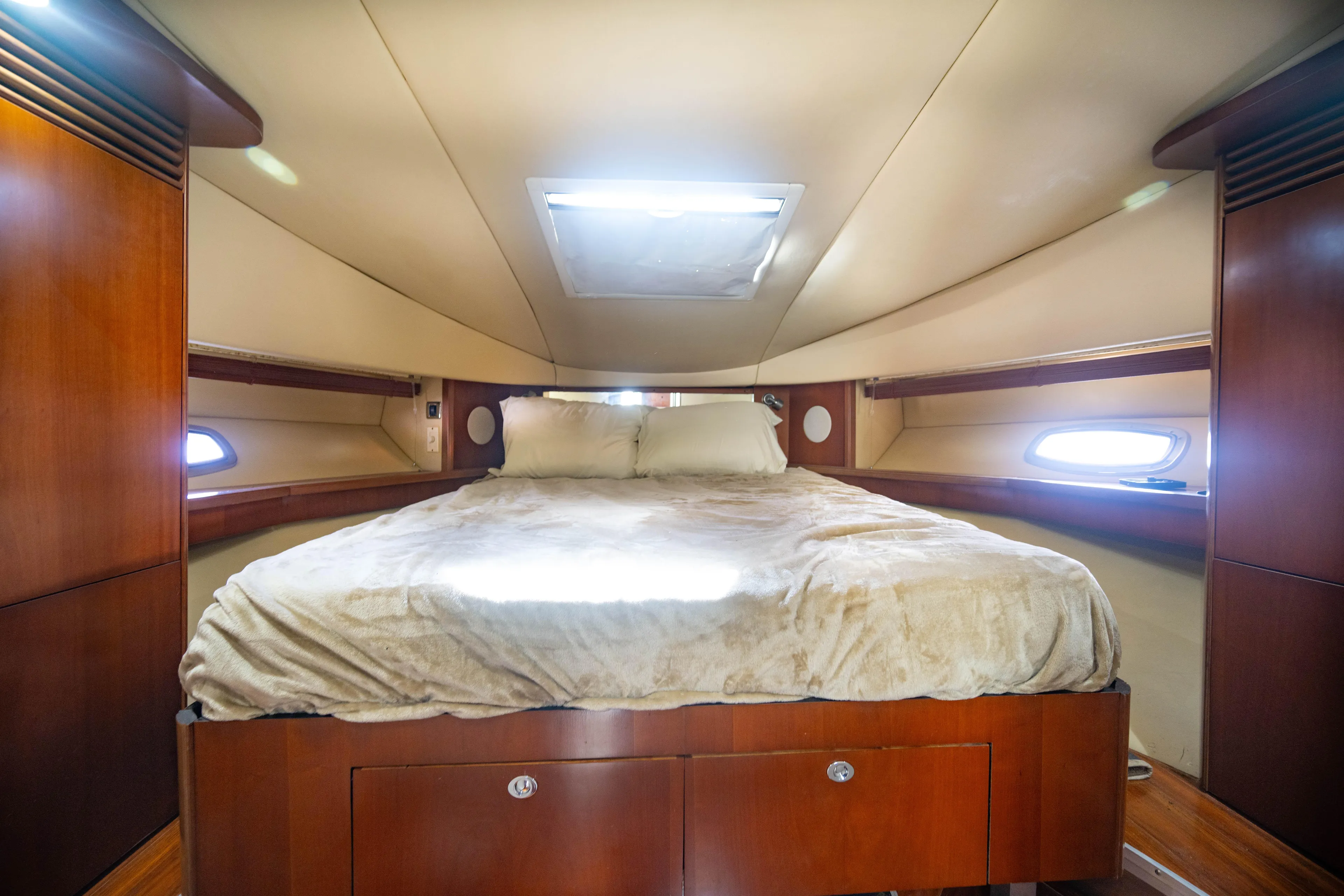  Yacht Photos Pics Luxurious cabin interior of 2006 Sea Ray 48 Sundancer yacht with cozy bed and wooden accents.