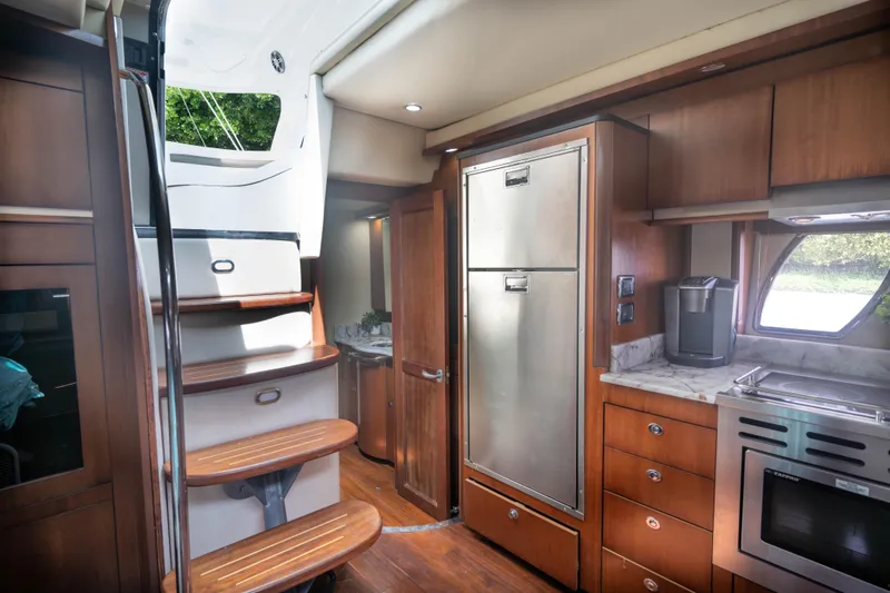  Yacht Photos Pics Interior of 2006 Sea Ray 48 Sundancer yacht with modern kitchen and wooden stairs.