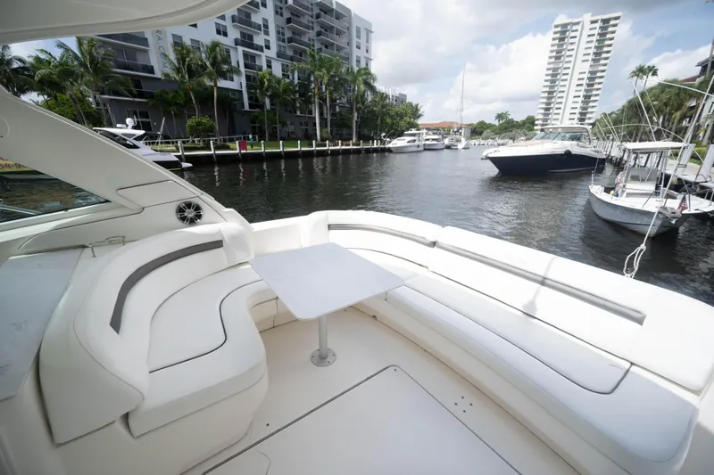  Yacht Photos Pics 2006 Sea Ray 48 Sundancer yacht with spacious seating, docked near waterfront buildings.