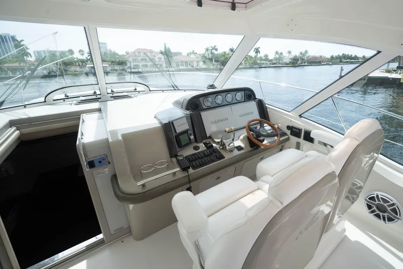  Yacht Photos Pics 2006 Sea Ray 48 Sundancer helm with Garmin navigation, luxurious seating, and waterfront view.