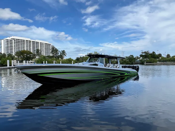 Yacht Photos Pics 2024 Nor-Tech 500 Sport boat on calm water with modern buildings in the background.