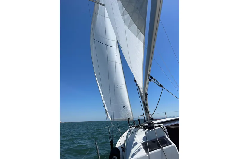 Polaris Yacht Photos Pics Sailing on a 2021 Beneteau Oceanis 30.1 with full sails under clear blue skies.
