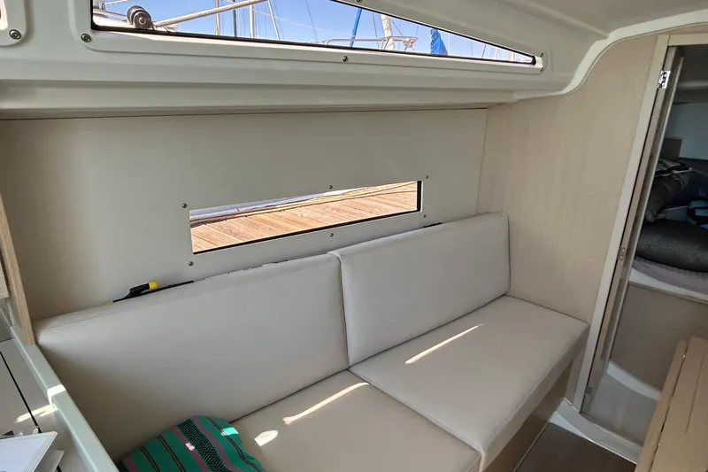 Polaris Yacht Photos Pics Interior of 2021 Beneteau Oceanis 30.1 yacht with beige seating and window view.