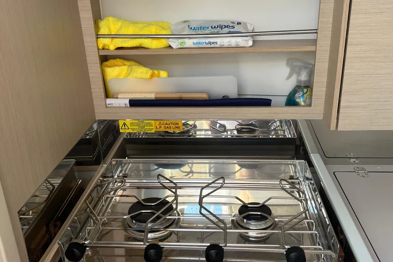 Polaris Yacht Photos Pics Compact kitchen area in a 2021 Beneteau Oceanis 30.1 yacht with stove and storage.