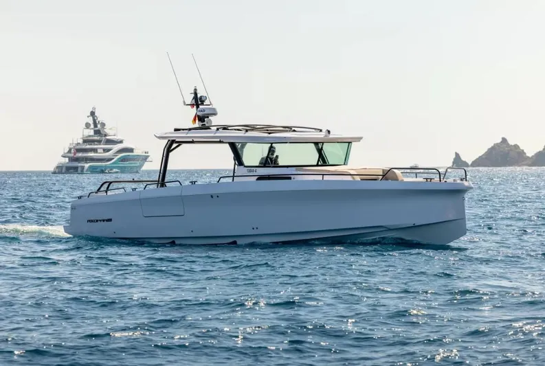  Yacht Photos Pics 2025 Axopar 45 Cross Top boat cruising on open sea with distant yacht.