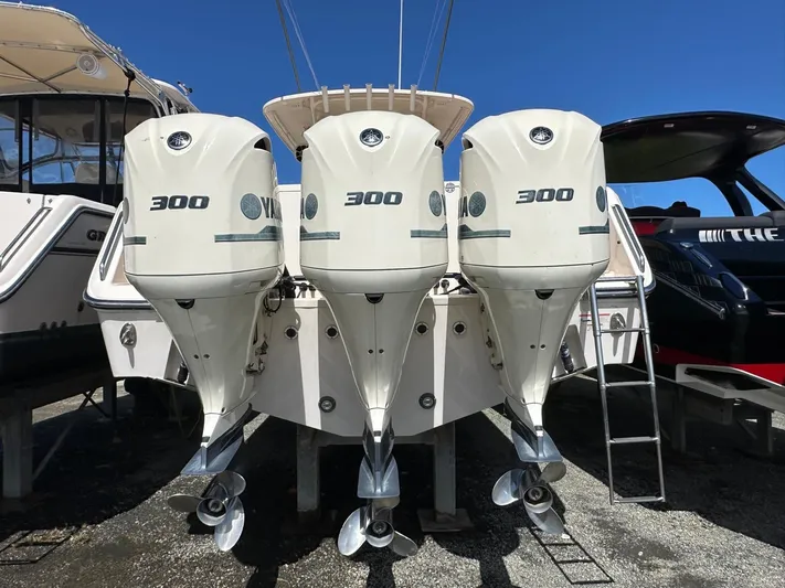  Yacht Photos Pics 2018 Grady-White Canyon 336 with triple 300 horsepower engines, docked under clear blue sky.
