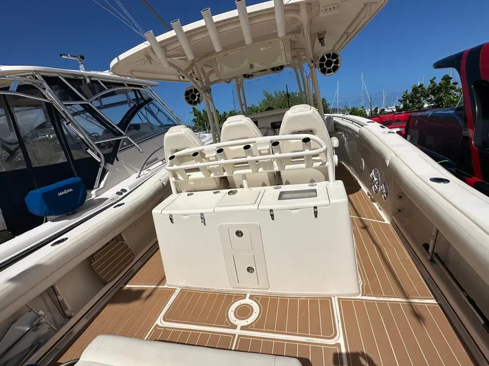  Yacht Photos Pics 2018 Grady-White Canyon 336 boat interior with seating and storage, docked under clear blue sky.