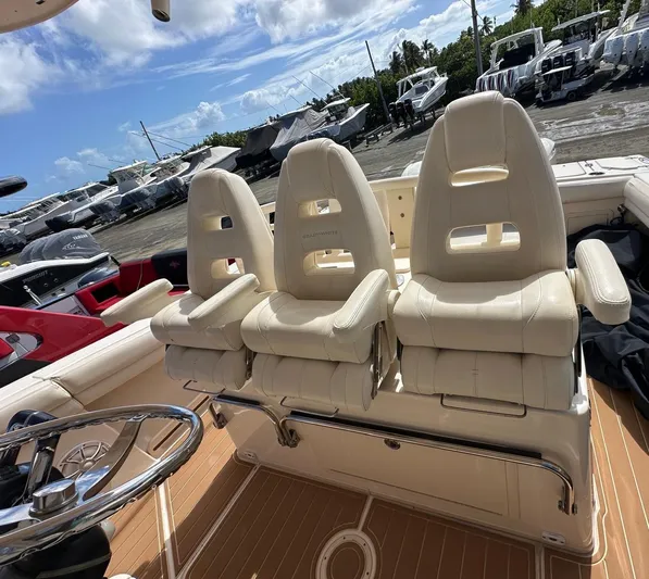 Yacht Photos Pics 2018 Grady-White Canyon 336 boat interior with three white cushioned seats and steering wheel.