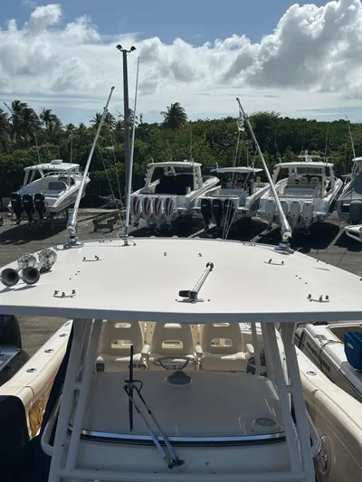  Yacht Photos Pics 2018 Grady-White Canyon 336 boat docked with other vessels under a partly cloudy sky.