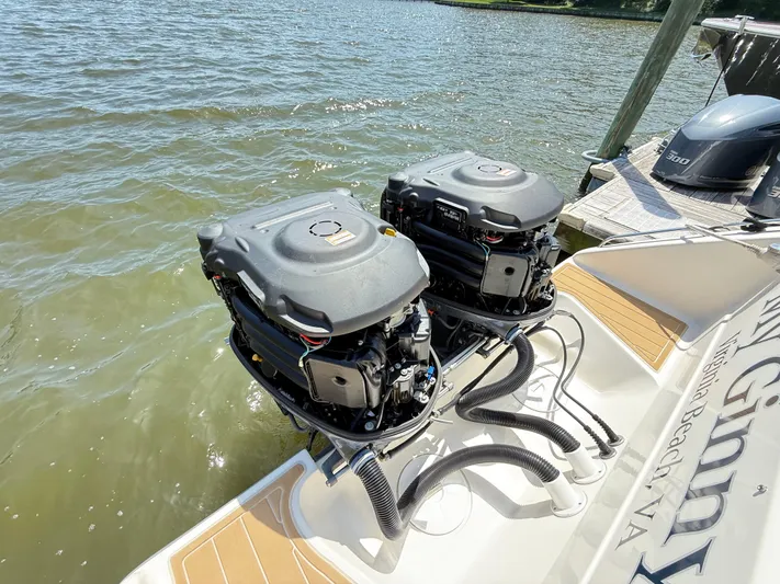 My Ginny Yacht Photos Pics Twin outboard engines on a 2014 Pursuit ST 310 Sport boat docked by the water.