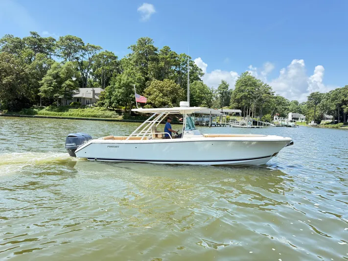 My Ginny Yacht Photos Pics 2014 Pursuit ST 310 Sport boat cruising on a scenic lake with lush greenery.