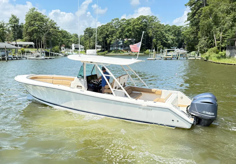 My Ginny Yacht Photos Pics 2014 Pursuit ST 310 Sport boat on a calm lake with trees in the background.