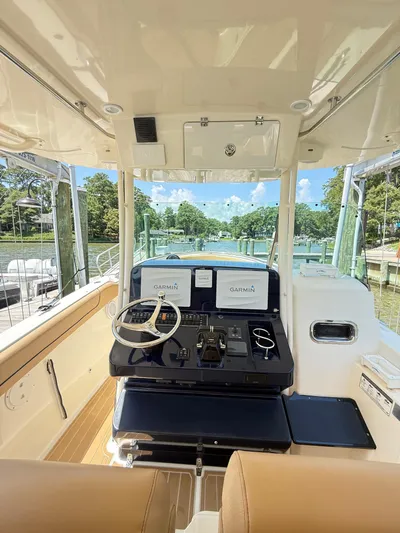 My Ginny Yacht Photos Pics 2014 Pursuit ST 310 Sport boat interior with Garmin navigation, docked by a scenic waterfront.