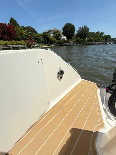 My Ginny Yacht Photos Pics 2014 Pursuit ST 310 Sport boat deck by a scenic waterfront.