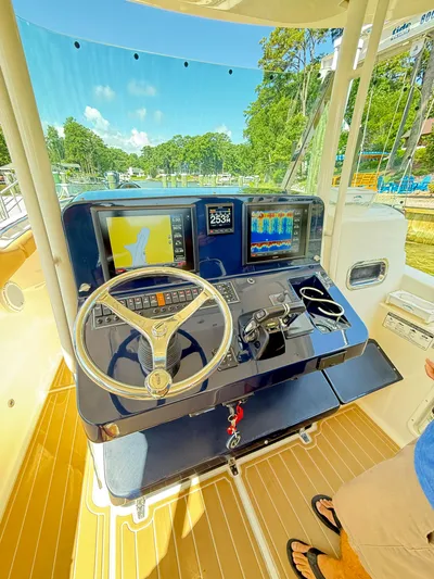My Ginny Yacht Photos Pics 2014 Pursuit ST 310 Sport boat helm with navigation screens and steering wheel.