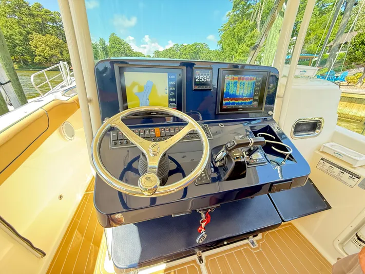 My Ginny Yacht Photos Pics 2014 Pursuit ST 310 Sport boat dashboard with navigation screens and steering wheel.