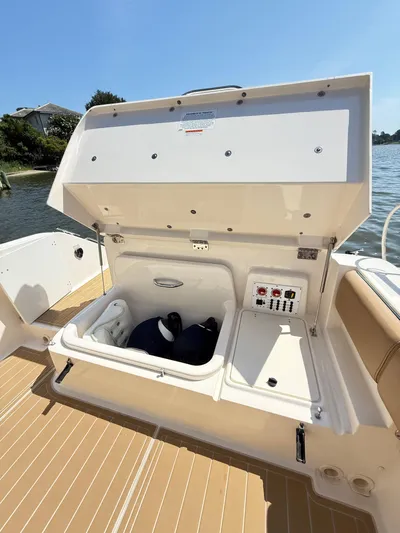 My Ginny Yacht Photos Pics 2014 Pursuit ST 310 Sport boat storage compartment open by the water.