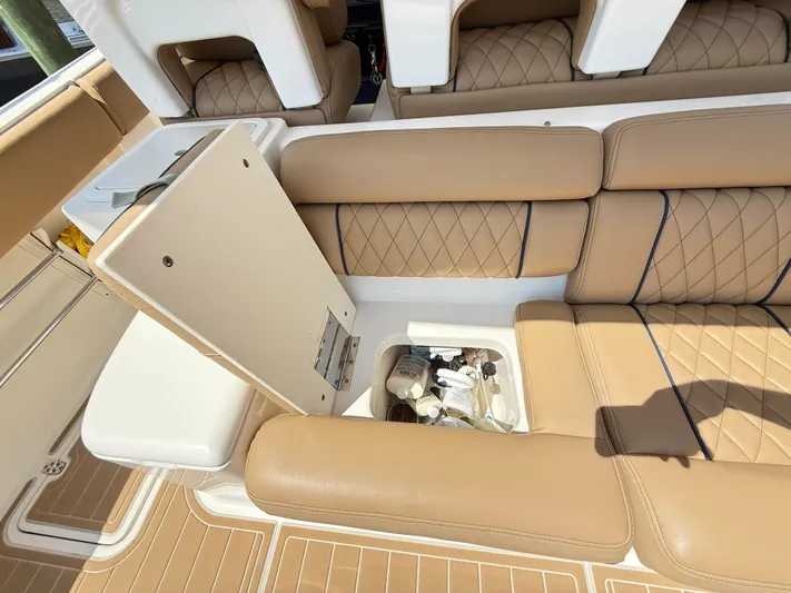 My Ginny Yacht Photos Pics 2014 Pursuit ST 310 Sport boat interior with tan leather seats and storage compartment.
