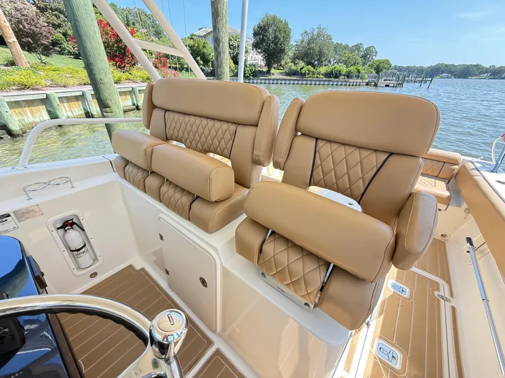 My Ginny Yacht Photos Pics Luxurious seating on 2014 Pursuit ST 310 Sport boat, featuring tan leather upholstery and scenic waterfront view.