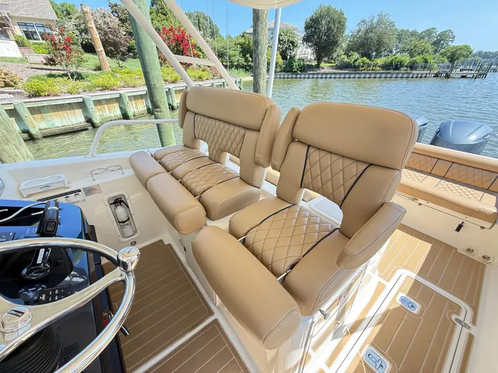 My Ginny Yacht Photos Pics Luxurious seating on 2014 Pursuit ST 310 Sport boat, with scenic waterfront view.