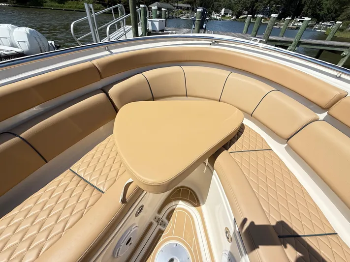 My Ginny Yacht Photos Pics Luxurious seating area on a 2014 Pursuit ST 310 Sport boat, docked by the water.