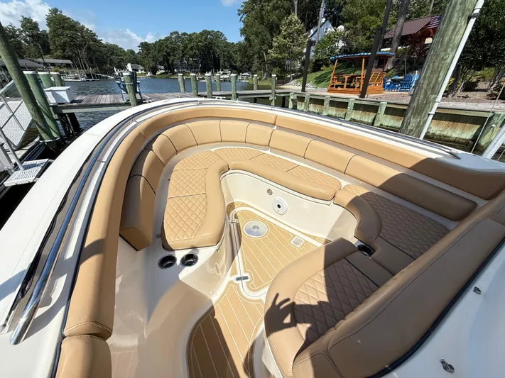 My Ginny Yacht Photos Pics 2014 Pursuit ST 310 Sport boat with tan seating, docked by a scenic waterfront.