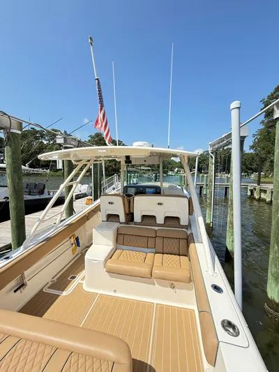 My Ginny Yacht Photos Pics 2014 Pursuit ST 310 Sport boat docked, featuring tan seating and American flag.