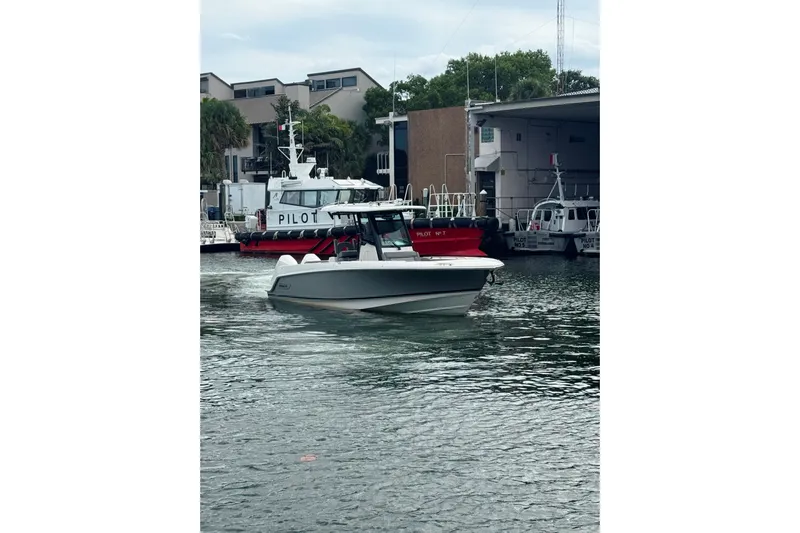  Yacht Photos Pics 2024 Boston Whaler 280 Outrage boat cruising near docked pilot boats.
