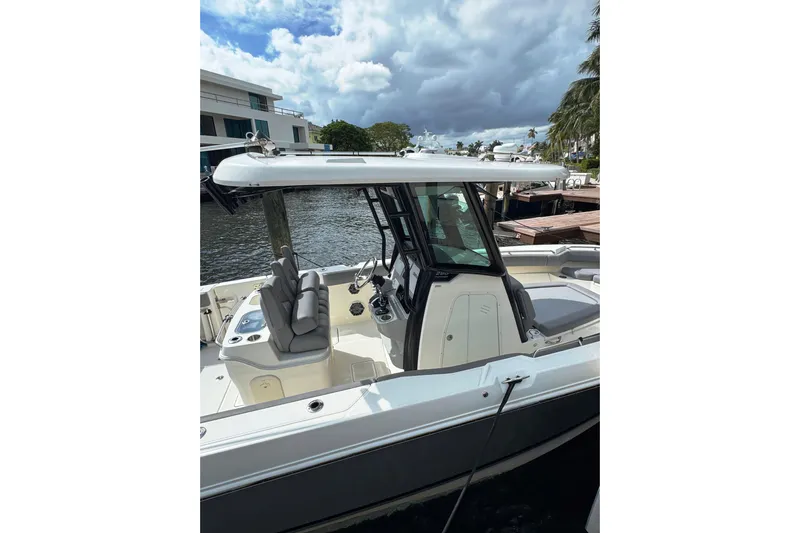  Yacht Photos Pics 2024 Boston Whaler 280 Outrage boat docked by waterfront, showcasing sleek design and seating.