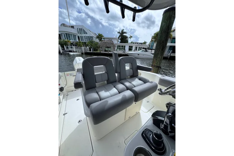  Yacht Photos Pics 2024 Boston Whaler 280 Outrage boat interior with gray seating and waterfront view.