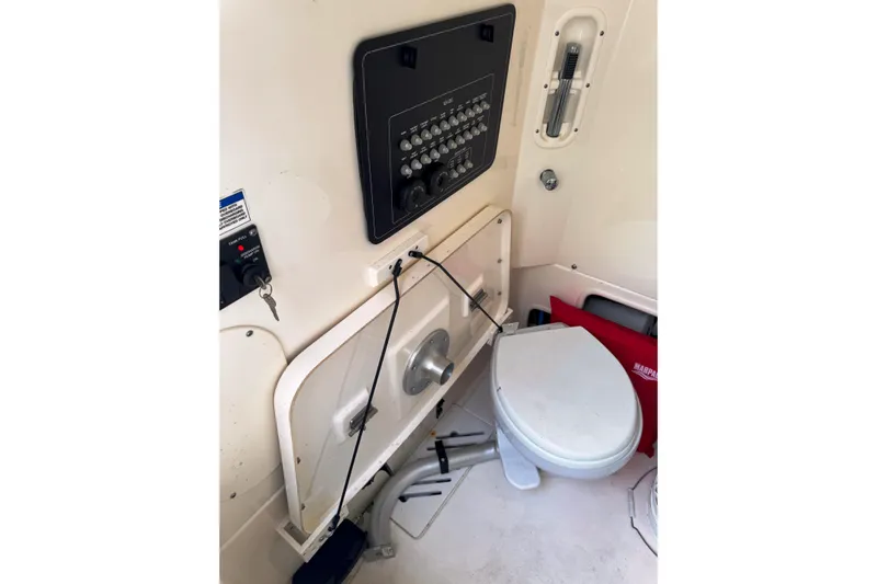  Yacht Photos Pics 2024 Boston Whaler 280 Outrage interior with control panel and marine toilet.