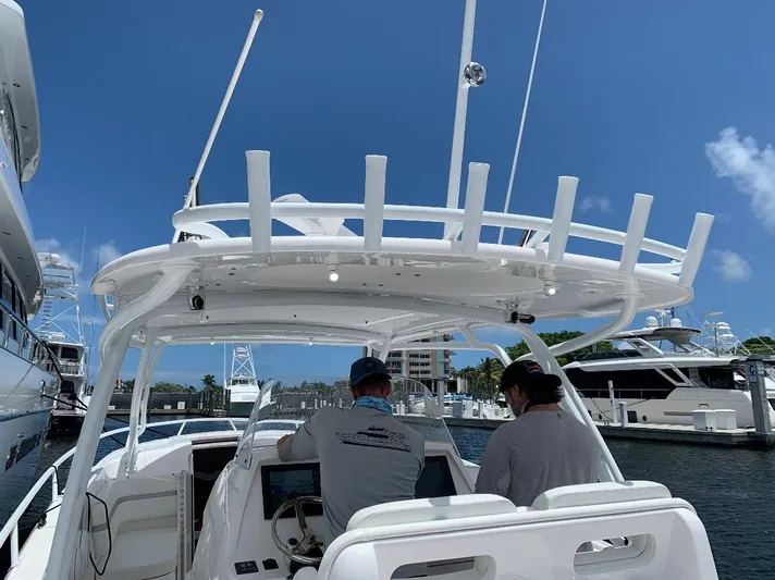  Yacht Photos Pics 2015 Intrepid 375 Walkaround boat at marina, two people at helm, clear blue sky.