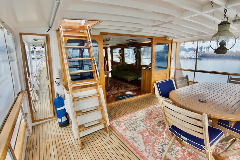 Grand Times Yacht Photos Pics 1969 Grand Banks Classic yacht interior with wooden deck, dining area, and staircase.