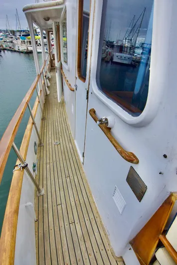 Grand Times Yacht Photos Pics 1969 Grand Banks Classic yacht deck with wooden railings, docked at a marina.