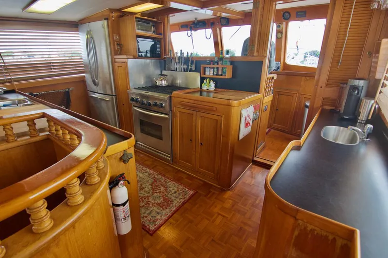 Grand Times Yacht Photos Pics Interior of a 1969 Grand Banks Classic yacht kitchen with wooden cabinetry and modern appliances.