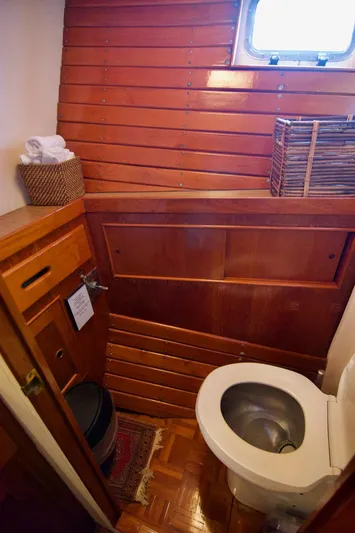 Grand Times Yacht Photos Pics 1969 Grand Banks Classic boat bathroom with wooden paneling and compact design.