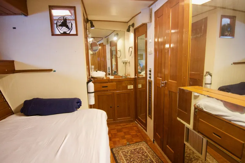 Grand Times Yacht Photos Pics 1969 Grand Banks Classic yacht interior with wooden cabinetry, bed, and mirror.