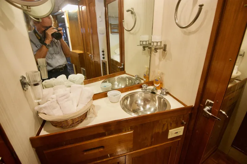 Grand Times Yacht Photos Pics 1969 Grand Banks Classic yacht bathroom with wooden cabinetry and stainless steel sink.