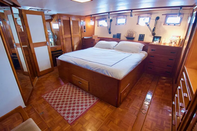 Grand Times Yacht Photos Pics Luxurious 1969 Grand Banks Classic yacht bedroom with wooden interior and cozy bed.