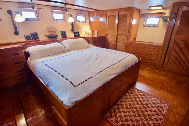 Grand Times Yacht Photos Pics Luxurious 1969 Grand Banks Classic yacht bedroom with wooden decor and cozy bedding.