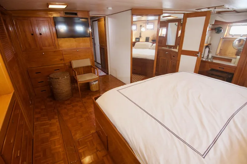 Grand Times Yacht Photos Pics 1969 Grand Banks Classic yacht interior with wood paneling, bed, and seating area.
