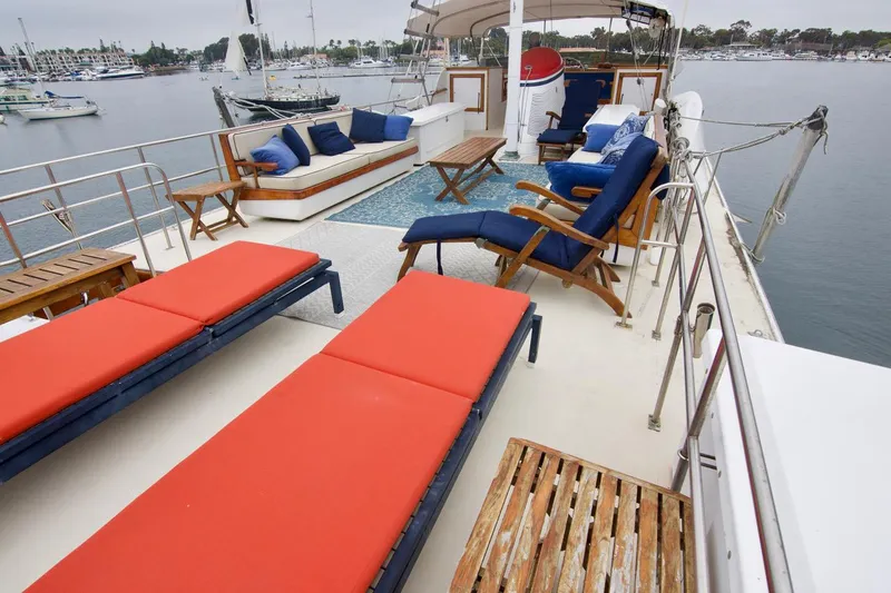 Grand Times Yacht Photos Pics Spacious deck of 1969 Grand Banks Classic yacht with red and blue lounge chairs.