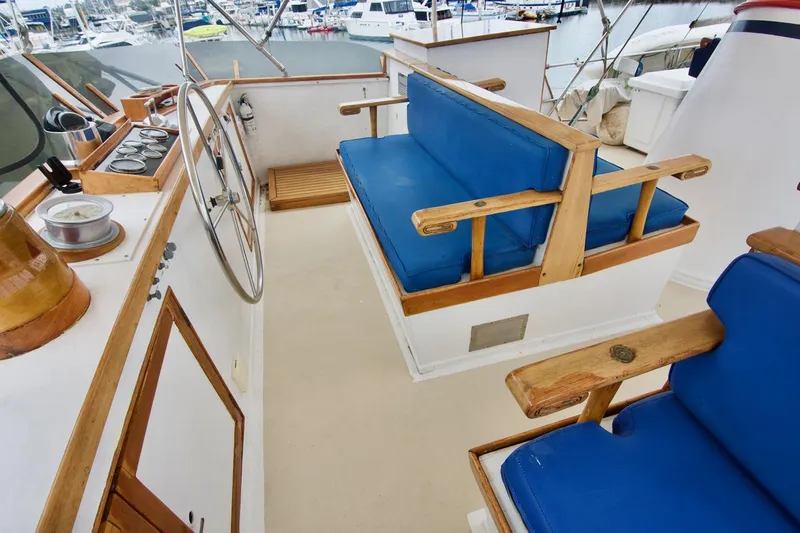Grand Times Yacht Photos Pics 1969 Grand Banks Classic boat interior with blue cushioned seating and wooden accents.