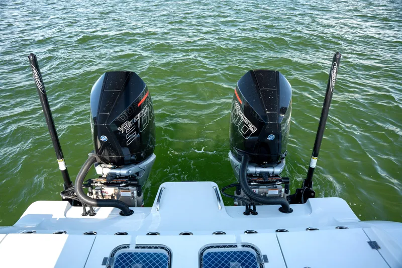  Yacht Photos Pics Twin outboard motors on a 2024 Freeman 28 boat in green water.