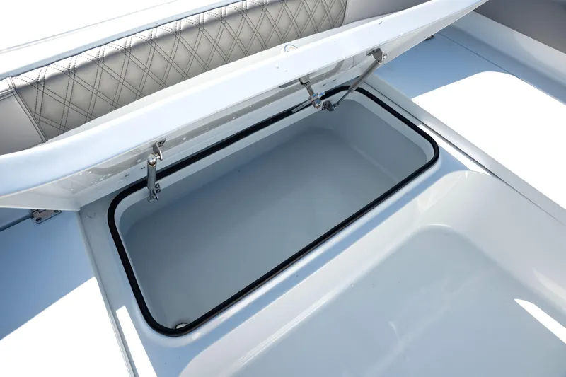  Yacht Photos Pics Open storage compartment on 2024 Freeman 28 boat with cushioned seating.