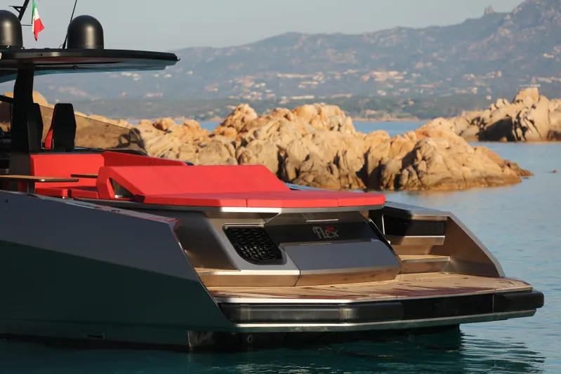 Maori 64 Yacht Photos Pics Luxury Maori M64 yacht, 2025 model, with sleek design and vibrant red seating, near rocky coastline.